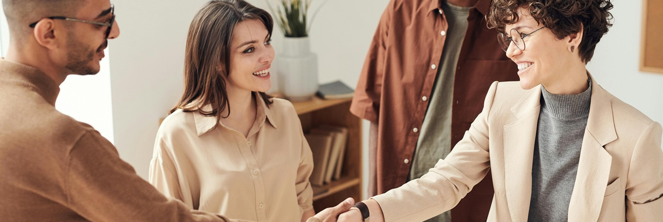 Entrepreneurs shake hands over a laptop, finalizing an e-commerce affiliate partnership for Giftideas.ca.